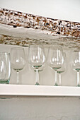 Wineglasses on shelf with wooden lintel in family townhouse Cornwall England UK
