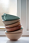 Pottery bowls and teacup on windowsill in holiday cottage Cornwall UK