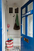 View into beach house through blue front door with brass letterbox Cornwall UK