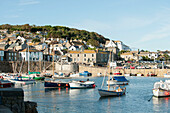 Fishing boats moored in harbour of Mousehole Cornwall UK
