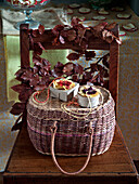 Handmade gift boxes on basket with beech leaves on wooden chair in UK home