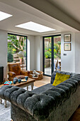 Buttoned grey sofa in garden extension of Tunbridge Wells home Kent England UK