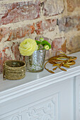 Cut flowers and jewellery on mantlepiece with exposed brickwork in Tunbridge Wells home Kent England UK