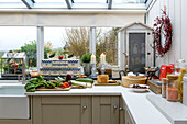 Fresh vegetables on kitchen worktop below window in Penzance home Cornwall UK