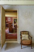 Small armchair with view through doorway in Helston farmhouse Cornwall UK