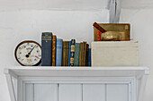 Barometer und Bücher mit festem Einband mit Mörser und Stößel auf einem Regal im Strandhaus in Marazion, Cornwall, Großbritannien