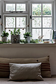 Evergreen foliage and garland on windowsill with cushions in St Erth cottage at Christmas Cornwall UK