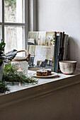 Evergreen foliage and books on windowsill in St Erth cottage at Christmas Cornwall UK