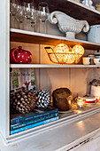 Lights in wire basket with homeware on dresser at Christmas in St Erth cottage Cornwall UK