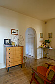 Vintage chest of drawers and armchair in London living room with wooden floor UK