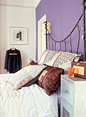 Bedroom with iron bedstead and purple painted wall