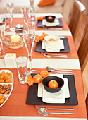 Festlich gedeckter Tisch in Schwarz und Orange