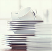 Stack of white plates bowls and cups 