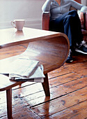 Frau entspannt sich in einem Sessel im Wohnzimmer mit Holzdielenboden
