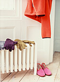 Gloves and slippers warming on radiator in hallway