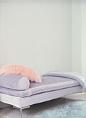 Lila Tagesbett mit rosa Kissen im Wohnzimmer