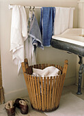 Slatted laundry basket with towels in bathroom