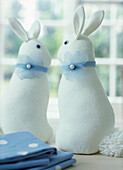 Two blue and white Easter bunny toys on a table