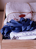 Ribbon and linen cloths in wooden box close-up