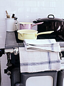 Close up of enamel pans on traditional cooker in tiled kitchen