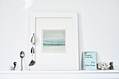 Artwork and books with ornaments on shelf in Lyme Regis home Dorset UK