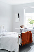 White double bed with orange blanket in Lyme Regis home Dorset UK
