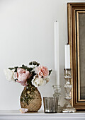 Cut flowers and candlesticks on mantlepiece in Lyme Regis home Dorset UK