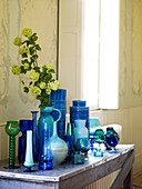 Collection of blue glassware and ceramics with yellow blossom
