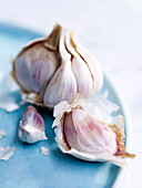 Fresh cloves of garlic on blue tray