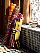 Stoffrollen und geometrische Kacheln in einem marokkanischen Riad in Nordafrika