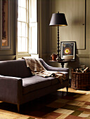 Lampe auf Beistelltisch mit Sofa und Holzkorb