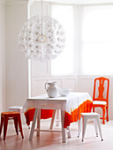 Eingefärbte Tischdecke mit orangefarbenem Stuhl in einem hellen Raum
