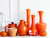 Collection of orange ceramics with dolls house chair