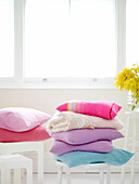 Stacked pastel cushions in bright interior