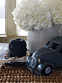 Vintage toy car and ball of black string with white hydrangea