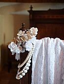 White roses and lace on foot of vintage bed in Sicilian home