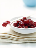 Cranberry sauce in bowl on folded fabric