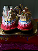 Gift wrapped presents and baubles in pair of woollen slippers