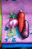 Novelty vegetable baubles on pink floral tablecloth