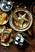Schokoladenmünzen und Goldstern mit Löffeln und Geschenken auf dem Tisch