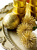 Gold baubles and tealight holders on tray