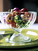 Assorted metallic baubles in glass bowl
