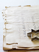 Metal p pastry cutter on old parchment with alphabet