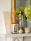 Candle holders with mirror and gift bag on mantlepiece