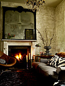 Retro furniture and lit fire with salvaged mirror frame