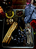 Tray with breadsticks and grapes on wooden table