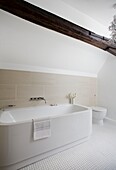 Freestanding bath in neutral timber framed cottage