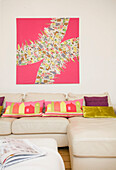 Pink artwork canvas above white leather sofa in Manchester family home, England, UK