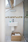 Shower cubicle and wash basin in bathroom of attic conversion in Manchester home, England, UK