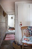 Eingangsflur und offene Haustür in einem Cottage in Corfe Castle, Dorset, England, UK